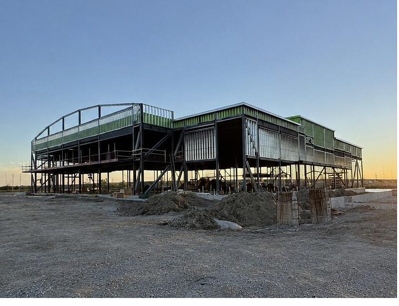 Elevated steel framing on a commercial building at sunset