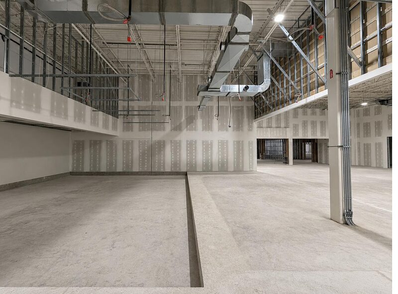 Large commercial interior with drywall demising walls and overhead systems